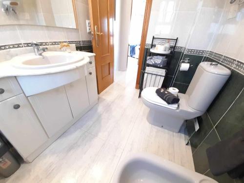 a bathroom with a white sink and a toilet at Apartamento de Pescado Azul Gandia playa con piscina ascensor y vistas al mar in Playa de Gandia