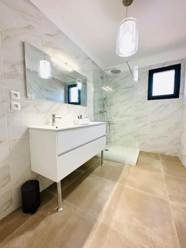 une salle de bain blanche avec un lavabo et un miroir dans l'établissement 