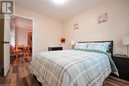 a bedroom with a bed and a dining room at Cozy 3 Bedroom Downtown Hideaway Cottage with Complimentary Breakfast in Niagara Falls