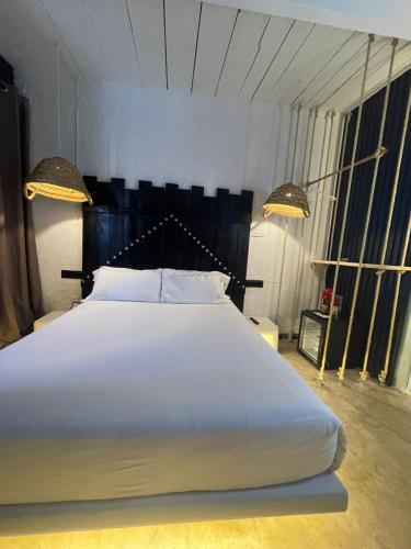a bedroom with a large white bed with two lamps at PAIISE Hotels in Sant Francesc de s'Estany