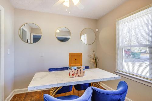 a dining room with blue chairs and mirrors at Pet-Friendly Georgia Retreat with Fire Pit and Porch! in Forest Park