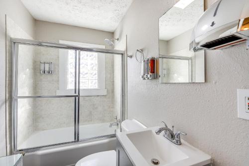 a white bathroom with a sink and a window at Pet-Friendly Georgia Retreat with Fire Pit and Porch! in Forest Park