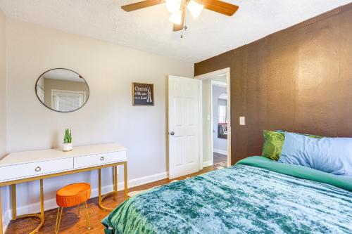 a bedroom with a bed and a dresser and a mirror at Pet-Friendly Georgia Retreat with Fire Pit and Porch! in Forest Park