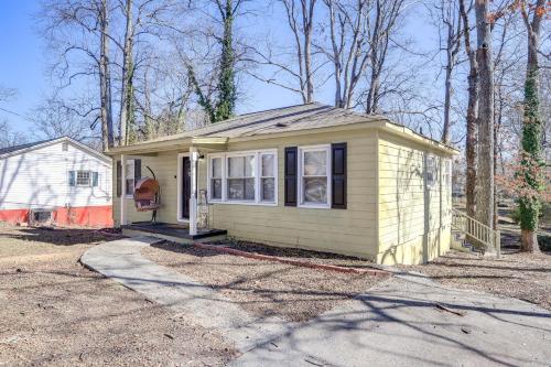 a small yellow tiny house in the woods at Pet-Friendly Georgia Retreat with Fire Pit and Porch! in Forest Park