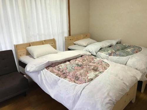 2 łóżka pojedyncze w pokoju z oknem w obiekcie SlowTime - Vacation STAY 75364v w mieście Shima