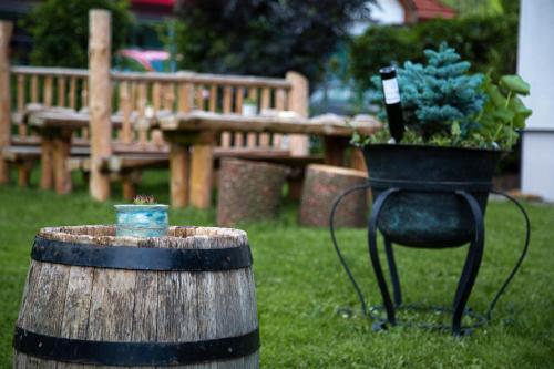a barrel with a potted plant on it next to a bench at Hotel-Restaurant-Café Krainer in Langenwang