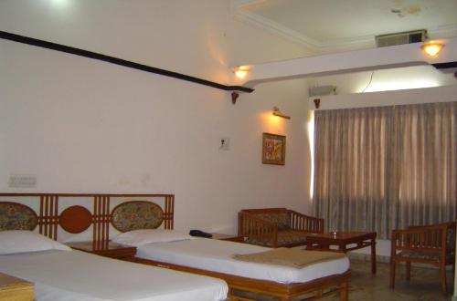 Ένα ή περισσότερα κρεβάτια σε δωμάτιο στο Amogha International Hotel