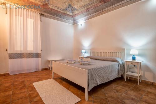 a bedroom with a bed and two tables and a window at Carlo Alberto Apartment, Alghero old town, near the beach in Alghero
