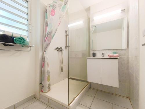 a shower with a glass door in a bathroom at La Bonne Adresse - 50 m de la mer in Sainte-Suzanne