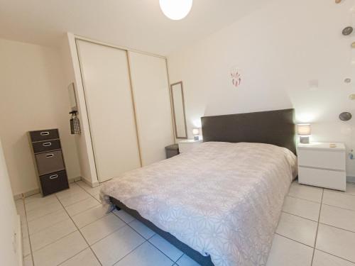 um quarto com uma cama e uma cómoda em La Bonne Adresse - 50 m de la mer em Sainte-Suzanne