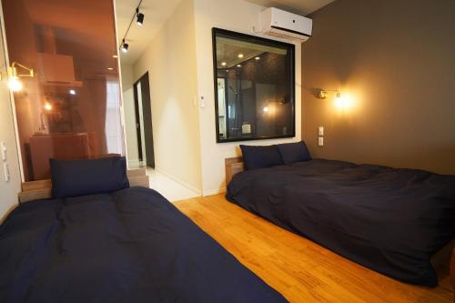1 dormitorio con 2 camas y ventana en Etcetera Niijima Nagisa Building - Vacation STAY 02083v, en Niijimamura