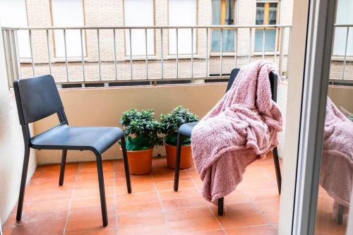 two chairs and a blanket on a balcony at Casa Coli in Sabiñánigo