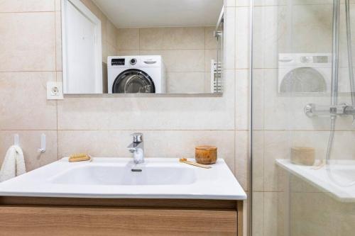 a bathroom with a sink and a washing machine at Casa Coli in Sabiñánigo