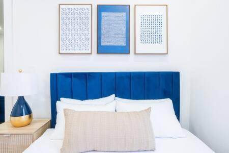 a blue headboard of a bed with a pillow and a lamp at Brand new 2BR 1Bath East Village in New York