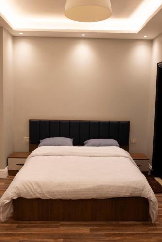 a bedroom with a large bed with white sheets at Munir’s residence in Cairo