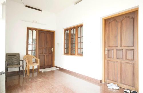 Cette chambre dispose d'une porte, d'une chaise et d'une table. dans l'établissement Good Palace, à Ernakulam