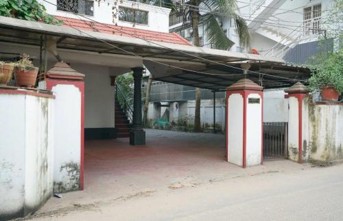 un vieux bâtiment avec des colonnes rouges et blanches dans une cour dans l'établissement Good Palace, à Ernakulam