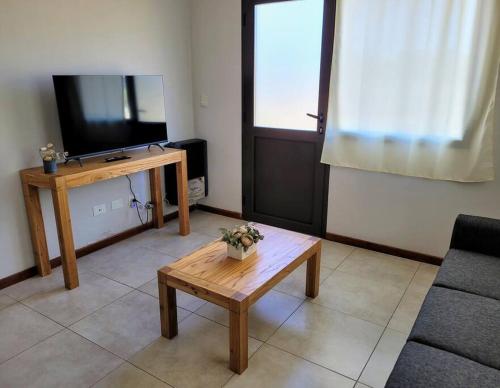- un salon avec une télévision et une table basse dans l'établissement Hospedaje El Toltén, à Junín de los Andes