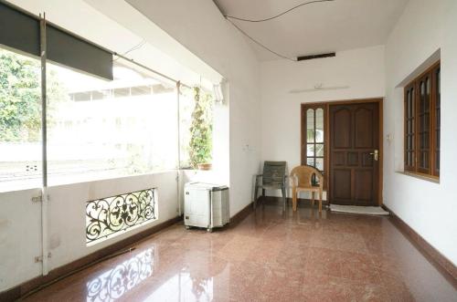 une pièce vide avec une grande fenêtre et une porte dans l'établissement Good Palace, à Ernakulam