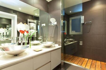 a bathroom with two sinks and two mirrors at Classy 3bed 3bath apartment in Eixample in Barcelona