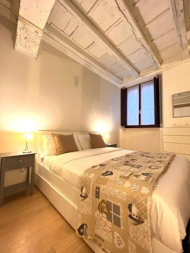 Un dormitorio con una cama grande y una ventana. en RESIDENZA SERENA SUITE-Centro Storico, en Mantua