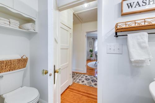 a bathroom with a white toilet and a hallway at Charming Virginia Retreat with Covered Porch and Yard! in Farmville