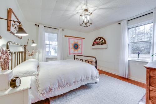 a bedroom with a bed and a desk and windows at Charming Virginia Retreat with Covered Porch and Yard! in Farmville