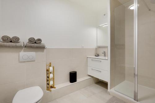 a white bathroom with a shower and a toilet at La Résidence Alpha Viroflay 201 - 1 chambre - 4 pers in Viroflay
