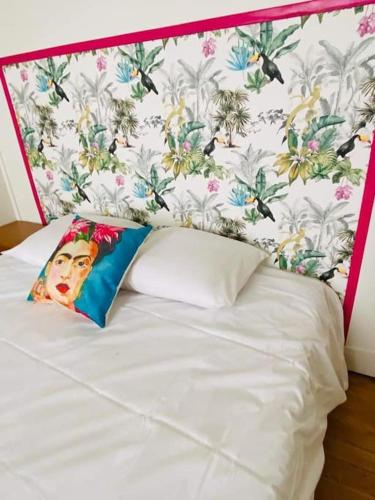 - un lit blanc avec tête de lit et une fresque murale représentant une femme dans l'établissement Chez Frida - 2 pers - BCLA, au Mans