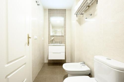 a white bathroom with a toilet and a sink at Capitan, 1 bedromm, city center & beach by 10TSea in Fuengirola