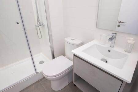 La salle de bains blanche est pourvue de toilettes et d'un lavabo. dans l'établissement Nuevo y Acogedor Departamento En Republica HOM, à Santiago