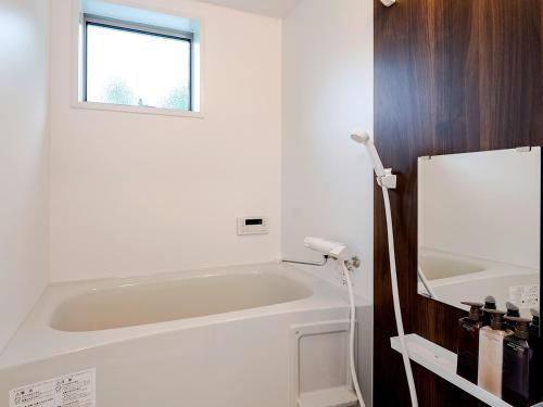 La salle de bains est pourvue d'une baignoire blanche et d'une fenêtre. dans l'établissement Class Besso Ise - Vacation STAY 61656v, à Iseji