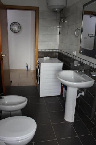 a bathroom with two sinks and a toilet and a mirror at CITY CENTER 2 in Shkodër