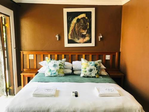 Un dormitorio con una cama con una foto de un león en Nomusa's Bed and Breakfast en Richards Bay