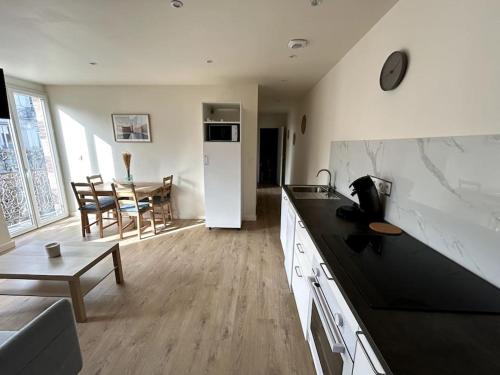 une cuisine et un salon avec un canapé et une table dans l'établissement Appartement lumineux en centre-ville / Proche Gare, à Saint-Chamond
