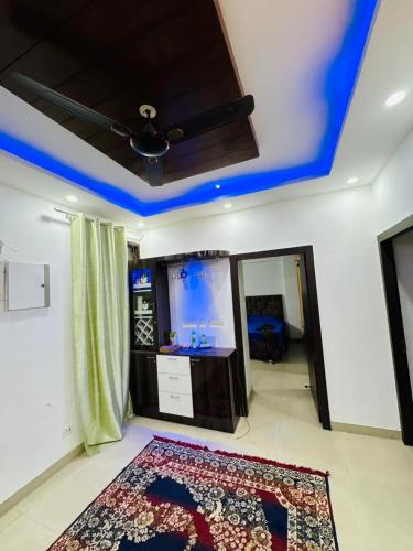 a living room with a blue ceiling and a rug at exclusive apartment for bash in Faridabad