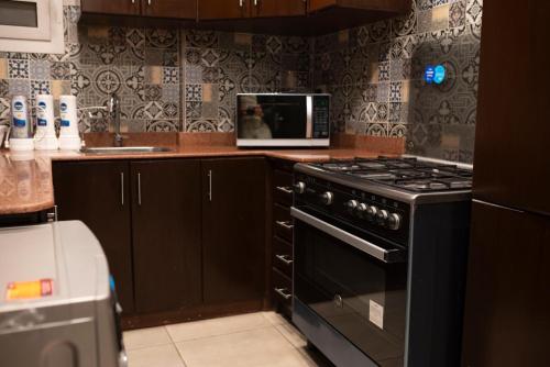 a kitchen with a stove and a microwave at Munir’s residence in Cairo