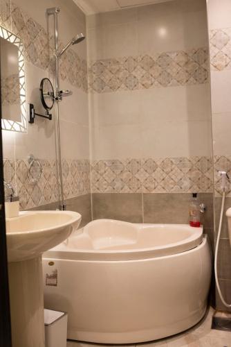 a bathroom with a white tub and a sink at Munir’s residence in Cairo