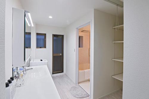 a white bathroom with a sink and a mirror at UMI-Haven Fukushima - Vacation STAY 16109 in Osaka