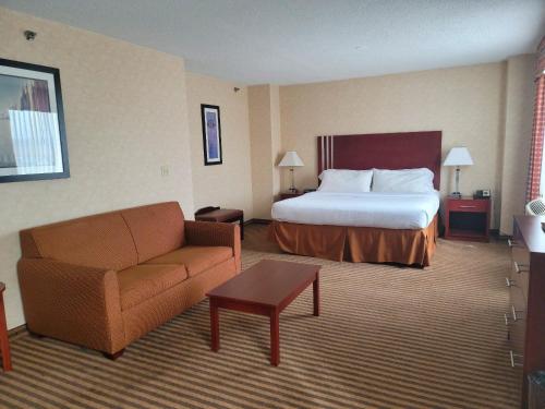 a hotel room with a bed and a couch at Lynchburg Grand Hotel in Lynchburg