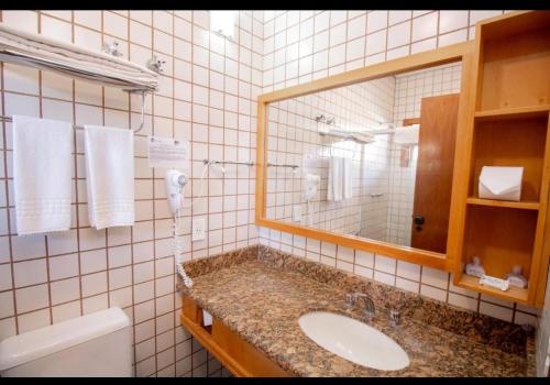 y baño con lavabo y espejo. en Beira mar Flat 2-209 en Ilhabela