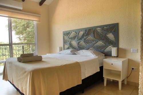a bedroom with a large bed with a large window at ISONDU Suites & Breakfast in Puerto Iguazú