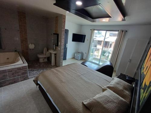 a bedroom with a bed and a tub and a television at HOTEL DULCES SUEÑOS in Buenaventura