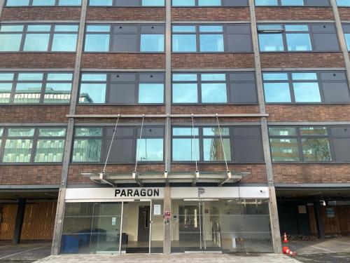 a tall brick building with a sign that reads paradigm at Stylish flat in Old Trafford in Manchester