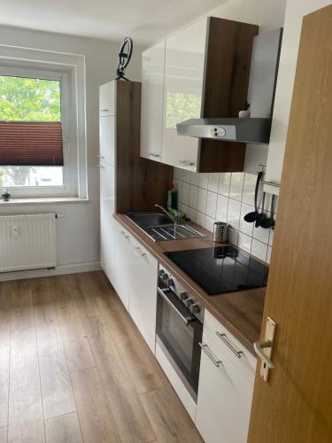 cocina con armarios blancos, fregadero y ventana en FeWo Wieko Plauen Leibnizstr. H1, 2.OG rechts, en Plauen