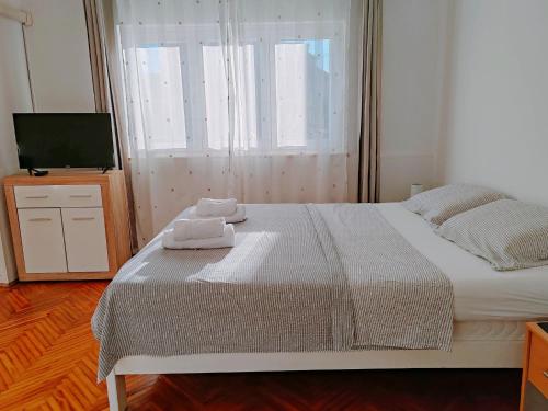 a bedroom with a bed with two towels on it at Apartmani Bojana in Rovinj