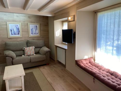 sala de estar con sofá y ventana en Apartamentos Calm & Nature en Liebana en Cabezón de Liébana