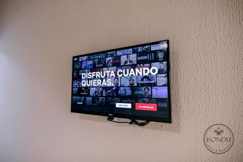 a flat screen tv hanging on a wall at ISONDU Suites & Breakfast in Puerto Iguazú