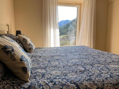 a bedroom with a large bed with a window at Apartamentos Calm & Nature - Adults Only in Cabezón de Liébana