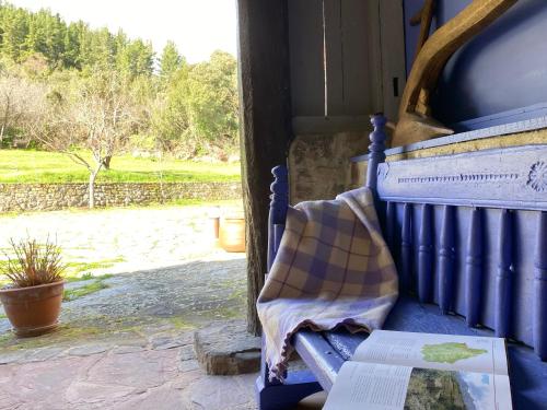 a blue bench with a blanket and a book on it at Apartamentos Calm & Nature - Adults Only in Cabezón de Liébana